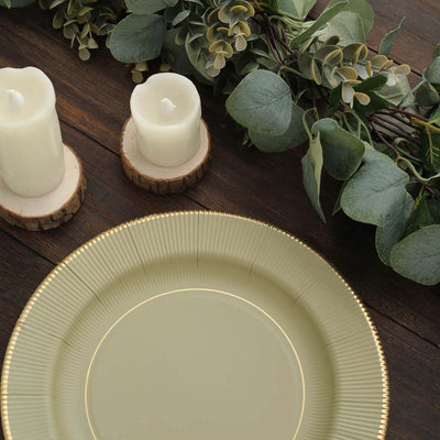 Elegant green plate with gold rim, surrounded by candles and greenery.