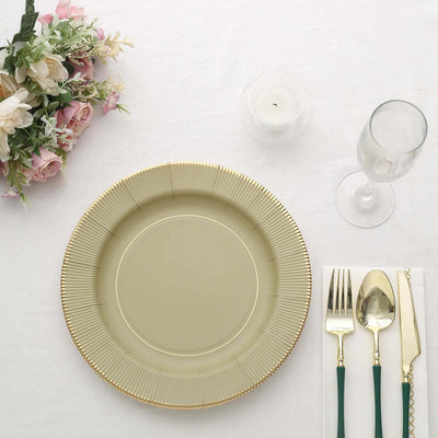 Elegant gold-rimmed plate with cutlery and floral arrangement
