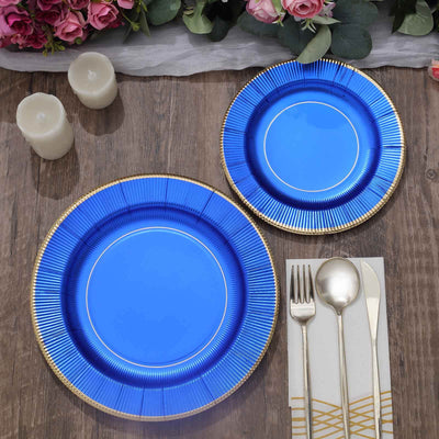 Blue decorative plates with gold trim on a wooden table setting.
