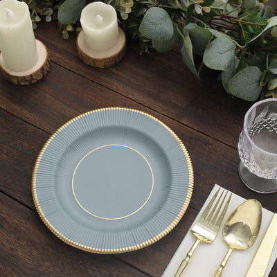 Elegant blue plate with gold rim on a rustic wooden table setting.