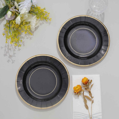 Elegant black plates with gold trim, arranged with floral accents.