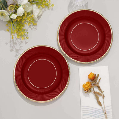Red decorative plates with gold trim, styled with flowers and napkin.