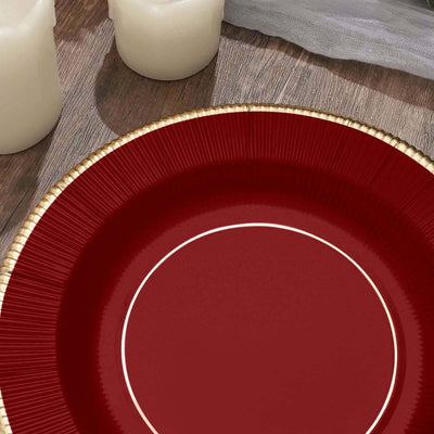 Elegant red plate with gold rim on a wooden surface.