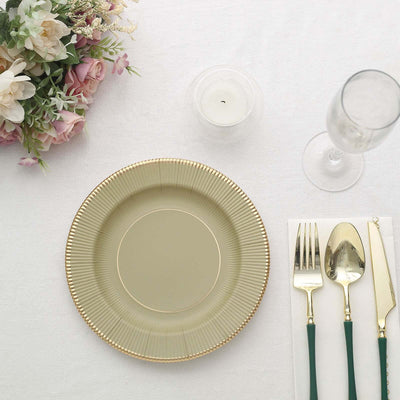 Elegant green plate with gold rim, set for dining with cutlery and glassware.