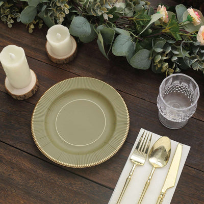 Elegant green plate with gold trim, surrounded by candles and silverware.
