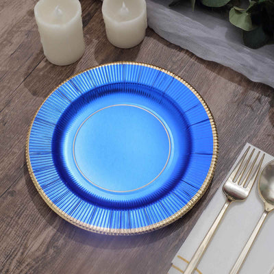 Blue decorative plate with gold rim on a wooden table setting.