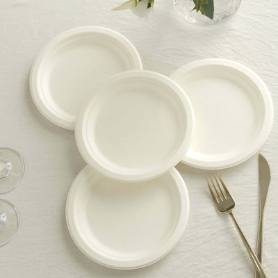 Set of four eco-friendly disposable paper plates on a textured tablecloth.