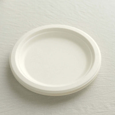 White disposable paper plates stacked on a neutral surface.