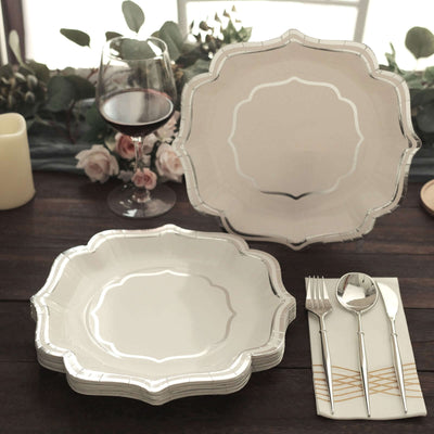 Elegant white dinner plates with silver trim set on a rustic table.