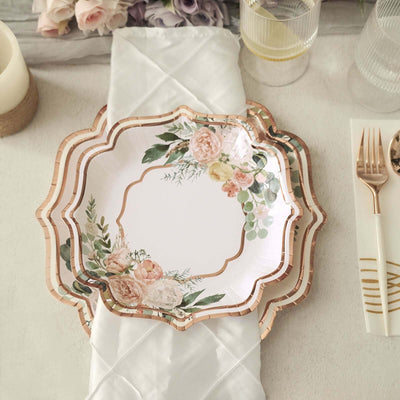 Elegant floral disposable plates with gold trim on a white napkin.