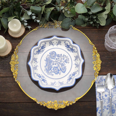 Elegant blue floral plate with ornate gold trim on a rustic wooden table.