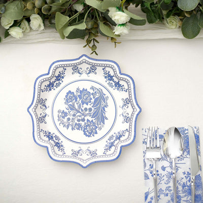 Blue floral decorative plate with utensils on a textured surface.