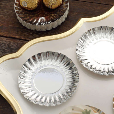 Silver disposable plates on a decorative tray.