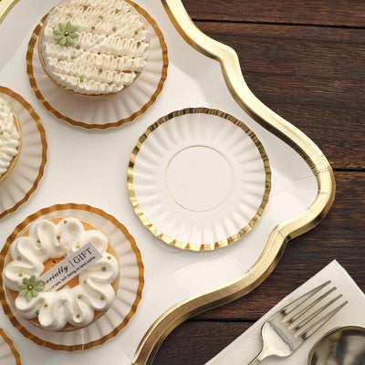 Decorative cupcakes on a tray with a blank plate and silver fork.