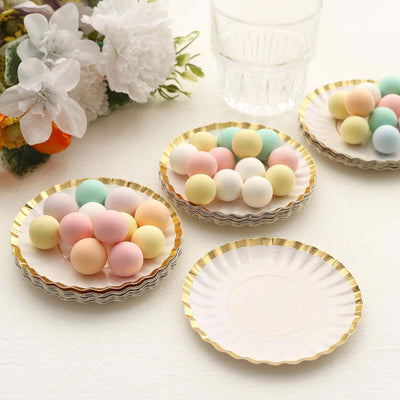 Pastel decorative candy balls on elegant plates with gold trim.