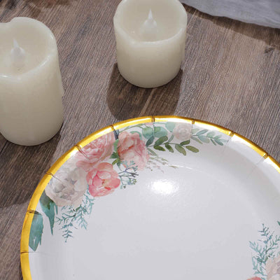 Floral decorative plate with gold trim and candles on a wooden surface.