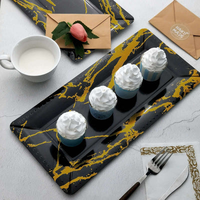 Stylish dessert cups with whipped cream on a decorative serving platter.