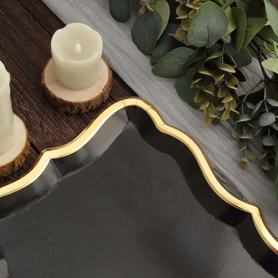 Elegant black serving tray with gold trim, styled with candles and greenery.