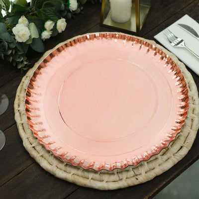 Rose gold charger plate on a woven placemat, set on a wooden table.