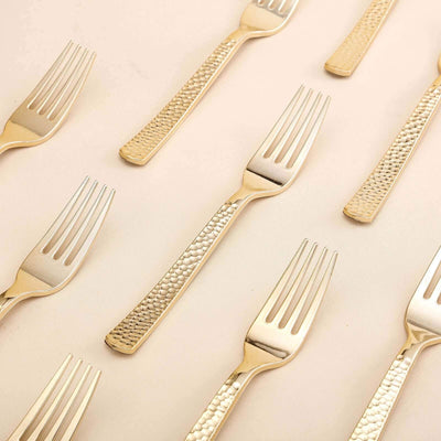 Gold textured dinner forks arranged on a neutral background.