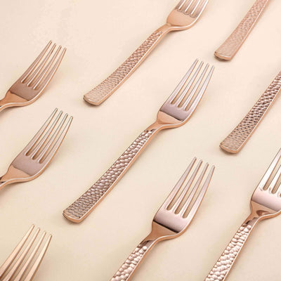 Rose gold forks arranged artistically on a soft beige background.