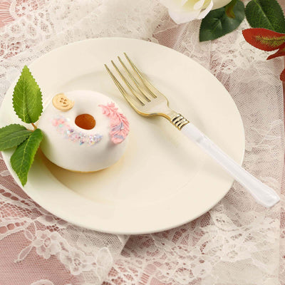 Decorative donut on a plate with a fork and fresh leaves.