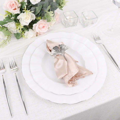 Elegant table setting with white plates, silver cutlery, and a floral centerpiece.