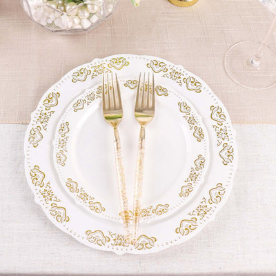 Elegant gold-accented dinnerware with matching forks on a textured table setting.
