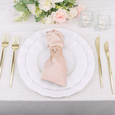 Elegant table setting with a pink napkin and gold accents.