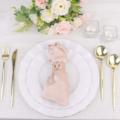 Elegant table setting with gold utensils, floral centerpiece, and decorative napkin.