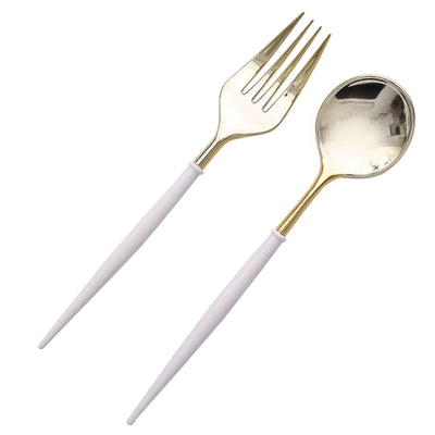 Gold and white serving fork and spoon set on a plain background.