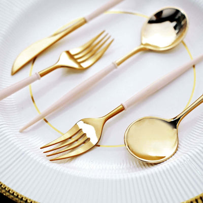 Elegant gold and pink cutlery set on a decorative plate.
