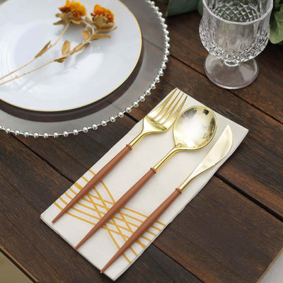 Elegant gold cutlery set on a stylish napkin and plate
