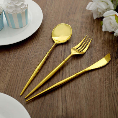 Gold stainless steel cutlery set on a wooden table.