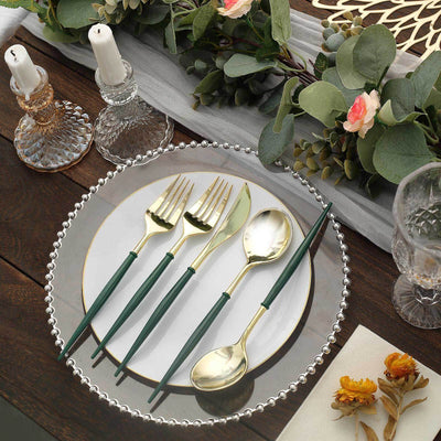 Elegant gold and green cutlery set on a decorative table setting.
