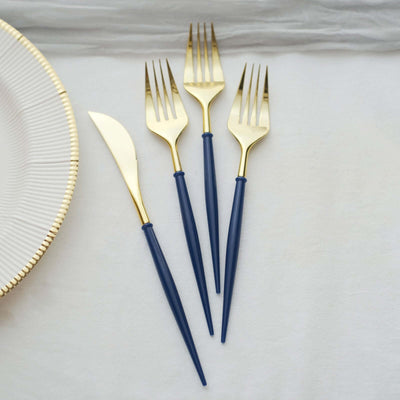 Gold and navy cutlery set of forks and knife on a neutral surface