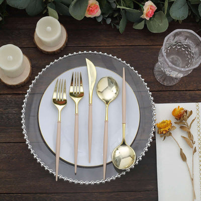 Elegant gold-accented cutlery set on a decorative plate with floral elements.