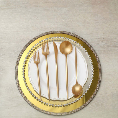 Elegant gold cutlery set on a decorative plate.