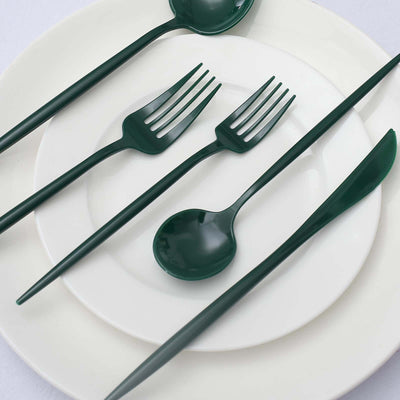 Green disposable cutlery set on white plates