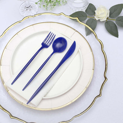 Blue cutlery set on an elegant white plate with a gold rim.