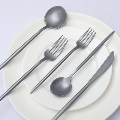 Modern silver cutlery set on white plates