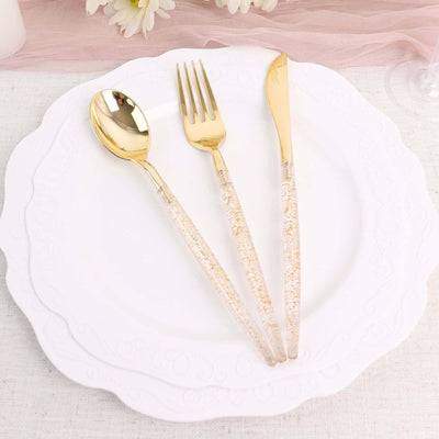 Gold-accented cutlery set with transparent handles on white plate