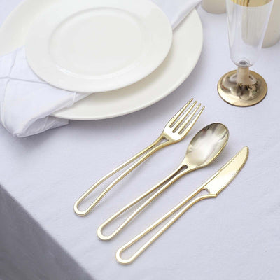 Elegant gold cutlery set with fork, knife, and spoon on a table setting.