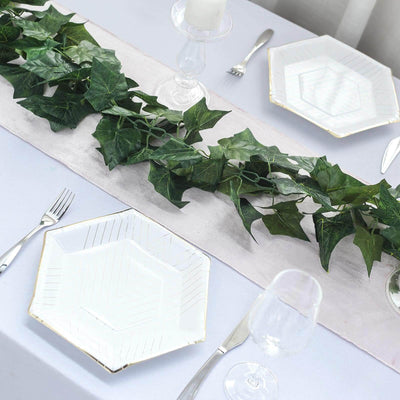 Elegant hexagonal plates with greenery on a beautifully set dining table.