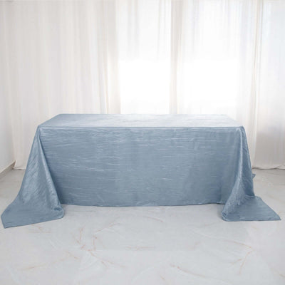 Light blue tablecloth draped over a table in a bright setting.