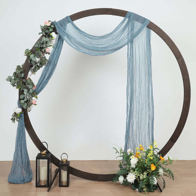 Decorative circular backdrop with draped fabric and floral accents.