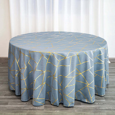 Round blue tablecloth with gold geometric pattern on a wooden surface.
