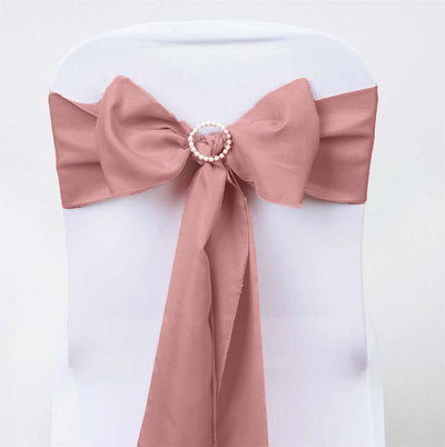 Blush pink chair sash with pearl ring detail on a white chair.