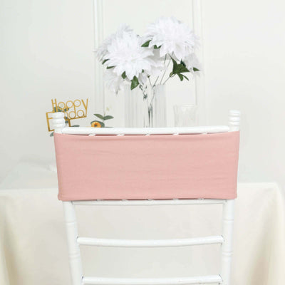 Pink chair cover on a white chair with flowers in the background.
