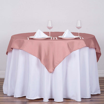 Elegant pink tablecloth draped over a round table set for dining.